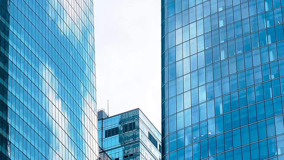 Blue glass skyscrapers in a city business district reflecting the sky