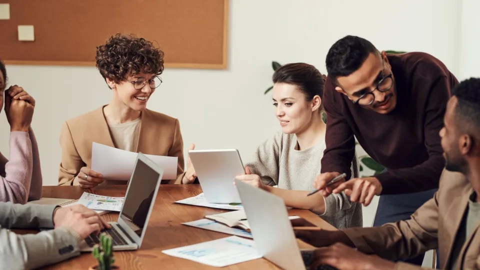 A diverse group of people working together around a wooden table